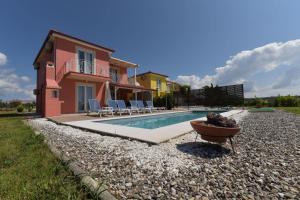 a villa with a swimming pool in front of a house at Iridia Resort Villas in Foiníki