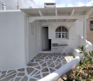 a white house with a patio with a table at Francesca Secret in Mikonos