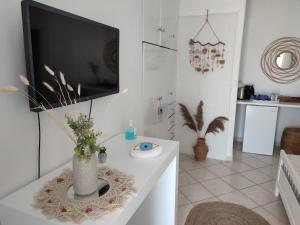 a living room with a tv and a white table at Francesca Secret in Mikonos