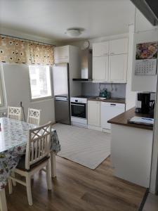 a kitchen with white cabinets and a table with a chair at Kempele city center in Kempele