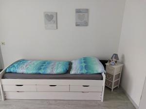 1 dormitorio con cama y mesita de noche en Schöner Weitblick, en Bad Sachsa