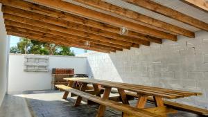 una mesa de picnic de madera en un patio con una pared de ladrillo en Parisito Sancti Petri, en Chiclana de la Frontera