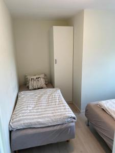 Dormitorio pequeño con 2 camas y armario en Havn i Etne, en Etnesjøen