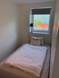 Dormitorio pequeño con cama y ventana en Havn i Etne, en Etnesjøen