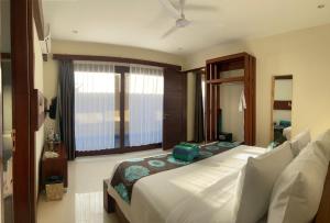 a bedroom with a large bed and a large window at Taj Maza Sunset Villas in Gili Trawangan +33 photos