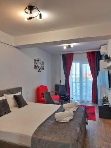 1 dormitorio con 1 cama grande y sillas rojas en Garsoniera Carmina, en Techirghiol