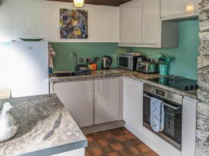 a kitchen with white cabinets and a counter top at The Coach House - Uk38044 in Beetham