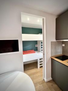 une petite chambre avec des lits superposés et une cuisine dans l'établissement La Sifflotte, centre Valberg, à Péone