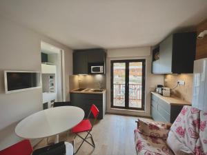 uma cozinha e sala de estar com mesa e cadeiras em La Sifflotte, centre Valberg em Péone