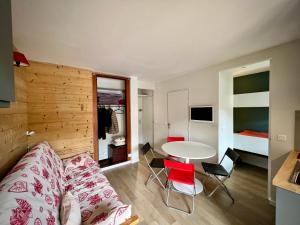 uma sala de estar com um sofá e uma mesa em La Sifflotte, centre Valberg em Péone