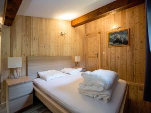 a bedroom with a bed with white sheets and pillows at Résidence Hôtel Rent - Megève Centre in Megève