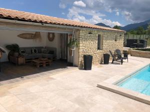 een huis met een patio en een zwembad bij Le Soustet in Malaucène