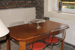 einem Holztisch mit zwei Stühlen und einem Teller darauf in der Unterkunft Le Moulin in Matton-et-Clémency