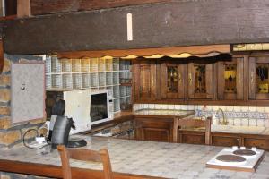 eine Küche mit Holzschränken und einer Arbeitsplatte in der Unterkunft Le Moulin in Matton-et-Clémency