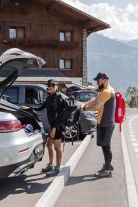 a man and a woman standing next to a car at Boutique Hotel Panorama in Crans-Montana