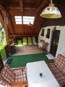 una camera con un tavolo e sedie verdi e un soffitto di Apartmaji Taler a Bohinj