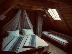 um quarto no sótão com 2 camas e uma janela em Home Eden Dobrenica em Bihać