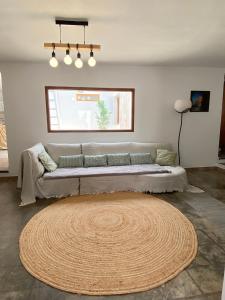 ein Wohnzimmer mit einem großen Sofa und einem großen Teppich in der Unterkunft CASA CALMA y LUZ in El Pozo de los Frailes