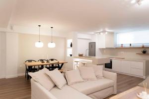 ein Wohnzimmer mit einem weißen Sofa und einer Küche in der Unterkunft Underground Luxury Living in Karystos