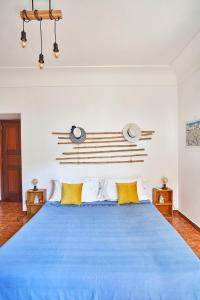 a bedroom with a blue bed with yellow pillows at Villa La Gitana in Anacapri
