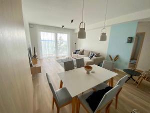 - un salon avec une table et des chaises blanches dans l'établissement Platan Garden Beach Balatonboglár 101, à Balatonboglár