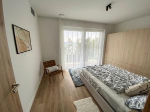 - une chambre avec un lit, une fenêtre et une chaise dans l'établissement Platan Garden Beach Balatonboglár 101, à Balatonboglár