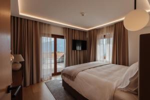 una camera d'albergo con un letto e una grande finestra di Boutique Hotel Panorama a Crans-Montana