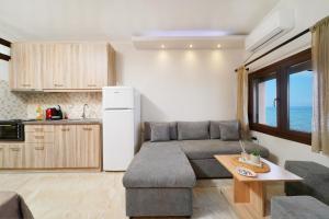 cocina y sala de estar con sofá y mesa en To Kyma - Seafront House, en Skala Kallirakhis