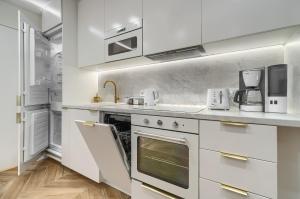 una cocina blanca con armarios y electrodomésticos blancos en Apartments Ostsee Suntowers, en Świnoujście