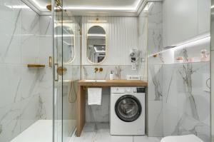 La salle de bains est pourvue d'un lave-linge et d'une douche. dans l'établissement Apartments Ostsee Suntowers, à Świnoujście