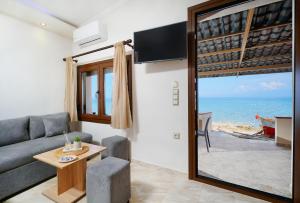 a living room with a couch and a view of the ocean at To Kyma - Seafront House in Skala Kallirakhis