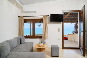 sala de estar con sofá y vistas al océano en To Kyma - Seafront House, en Skala Kallirakhis