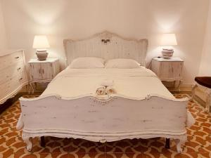 um quarto com uma grande cama branca com duas mesas de cabeceira em Il rifugio di Bacco em Trapani