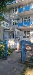 a building with a blue fence in front of it at Apartamenty Neptun in Świnoujście
