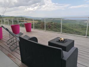 a balcony with a table and chairs on a deck at CHAMBRE AVENTURE VUE EXCEPTIONNELLE PORTICCIO in Porticcio