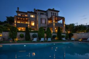 a large house with a swimming pool in front of it at Villa Marina, Sea View Luxury Villa in Mati
