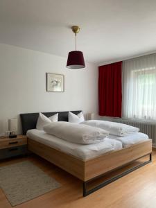 - une chambre avec un grand lit et un rideau rouge dans l'établissement Ferienwohnung Zita Weber, à Neustift im Stubaital