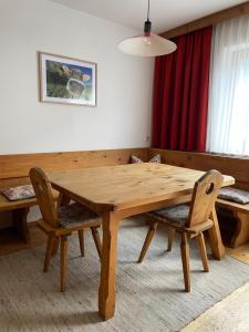 una mesa de madera y sillas en la sala de estar. en Ferienwohnung Zita Weber, en Neustift im Stubaital