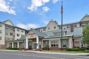 an exterior view of a hotel with an american flag at Residence Inn by Marriott Denver Airport at Gateway Park in Aurora