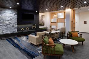 a living room with a couch and a table at Fairfield Inn & Suites by Marriott Charlotte University Research Park in Charlotte