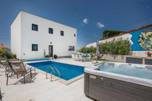 a villa with a swimming pool and a house at Villa Alma Krk in Krk