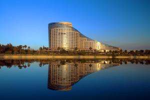 un edificio con su reflejo en un cuerpo de agua en Sheraton Grand Adana, en Adana