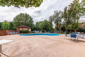 un patio con sillas y una piscina en Four Points by Sheraton Greensboro Airport, en Greensboro