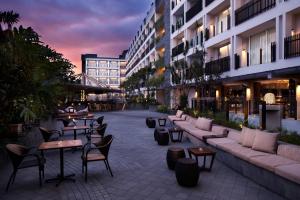 a courtyard with tables and chairs in a building at Fairfield by Marriott Bali Legian in Legian