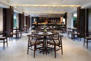 a restaurant with tables and chairs and a bar at Fairfield by Marriott Bali Legian in Legian