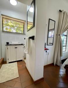a bathroom with a sink and a mirror at The White House in Hartbeespoort