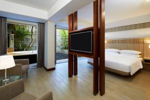 a bedroom with a bed and a flat screen tv at Fairfield by Marriott Bali Legian in Legian
