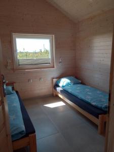 a small room with two beds and a window at Zante Sarbinowo in Sarbinowo