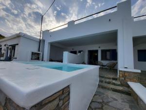 uma casa branca com uma piscina em frente em ΚΑΤΟΙΚΙΑ ΜΕ ΜΙΝΙ ΠΙΣΙΝΑ ΣΤΗΝ ΠΑΡΑΛΙΑ 3 Larerooms 3 em Kythnos