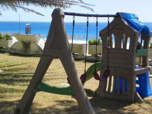a playground with a slide in front of the ocean at Estella Club in Montepaone